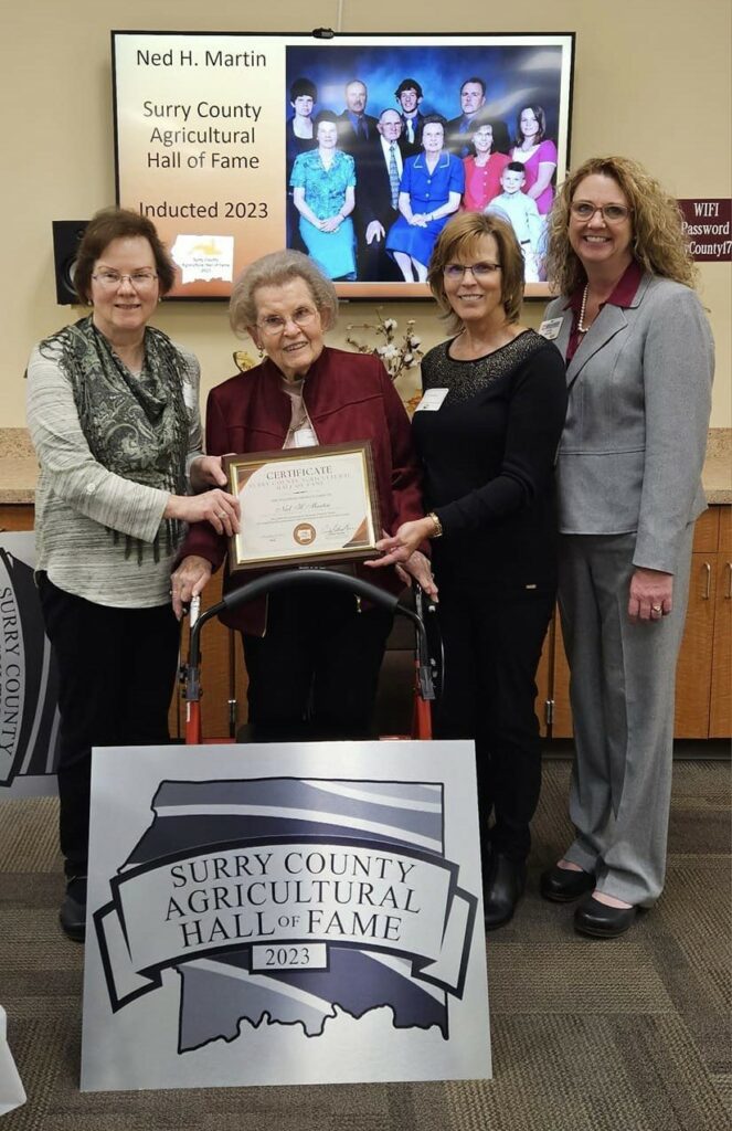 A woman is presented with a plaque for the Surry County Agricultural Hall of Fame.